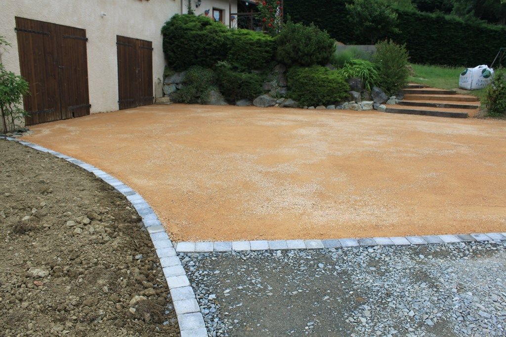 Cour en gravier stabilisé bordée de pavés granit devant une maison — Vaucluse