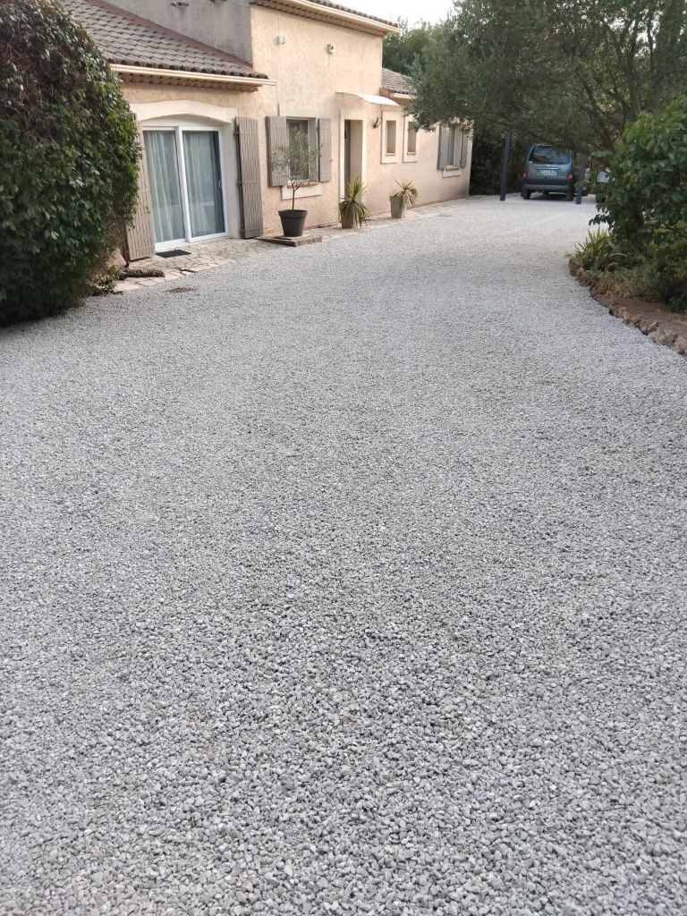 Cour d'accès en gravier gris devant maison provençale